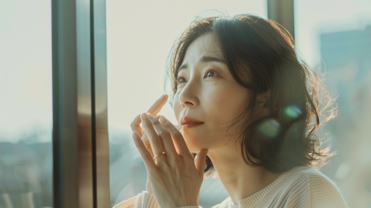手の甲のシミを気にしてハンドクリームを塗る40代女性